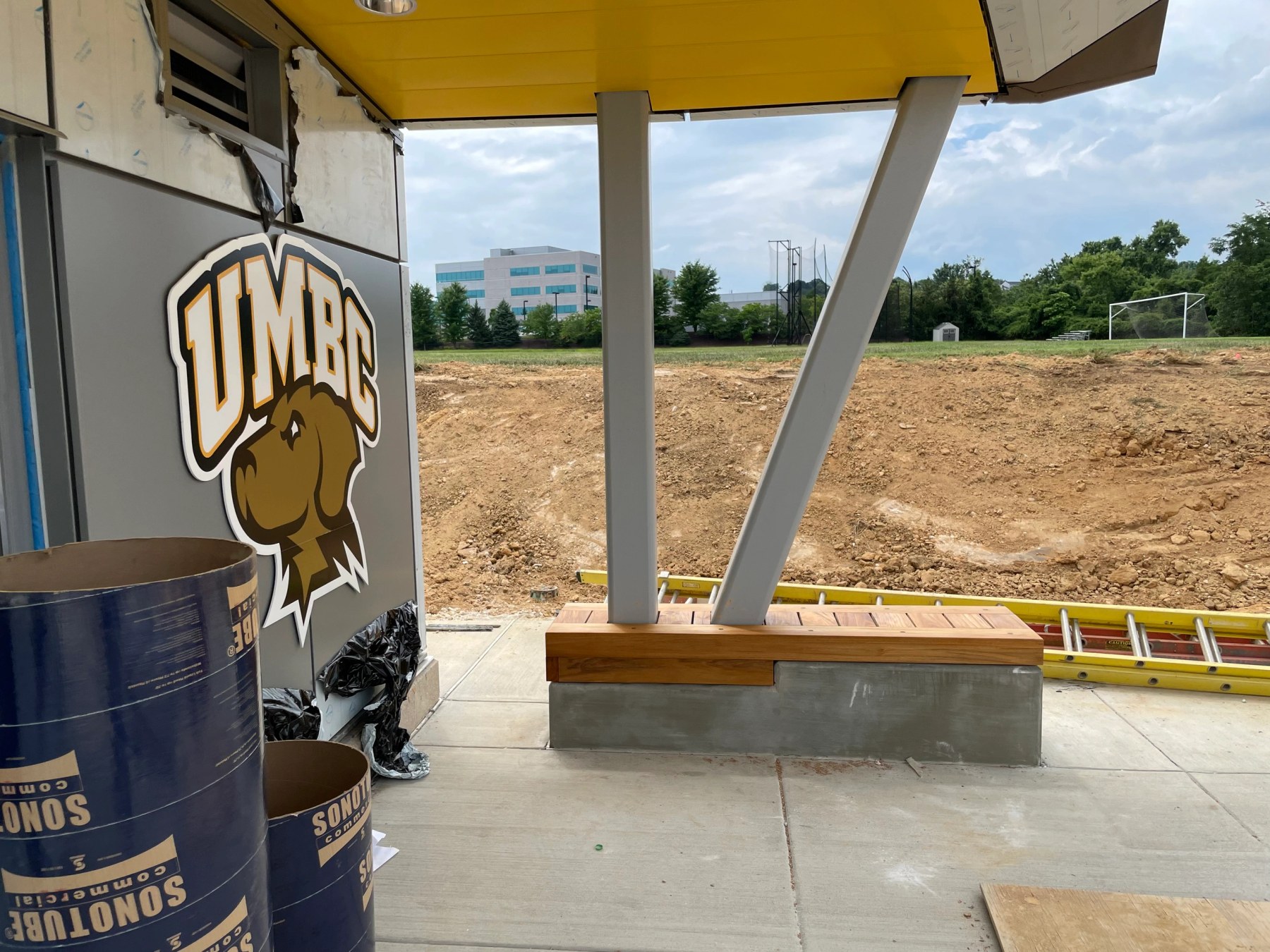 Steel canopy and timber bench at a commercial athletic facility under construction