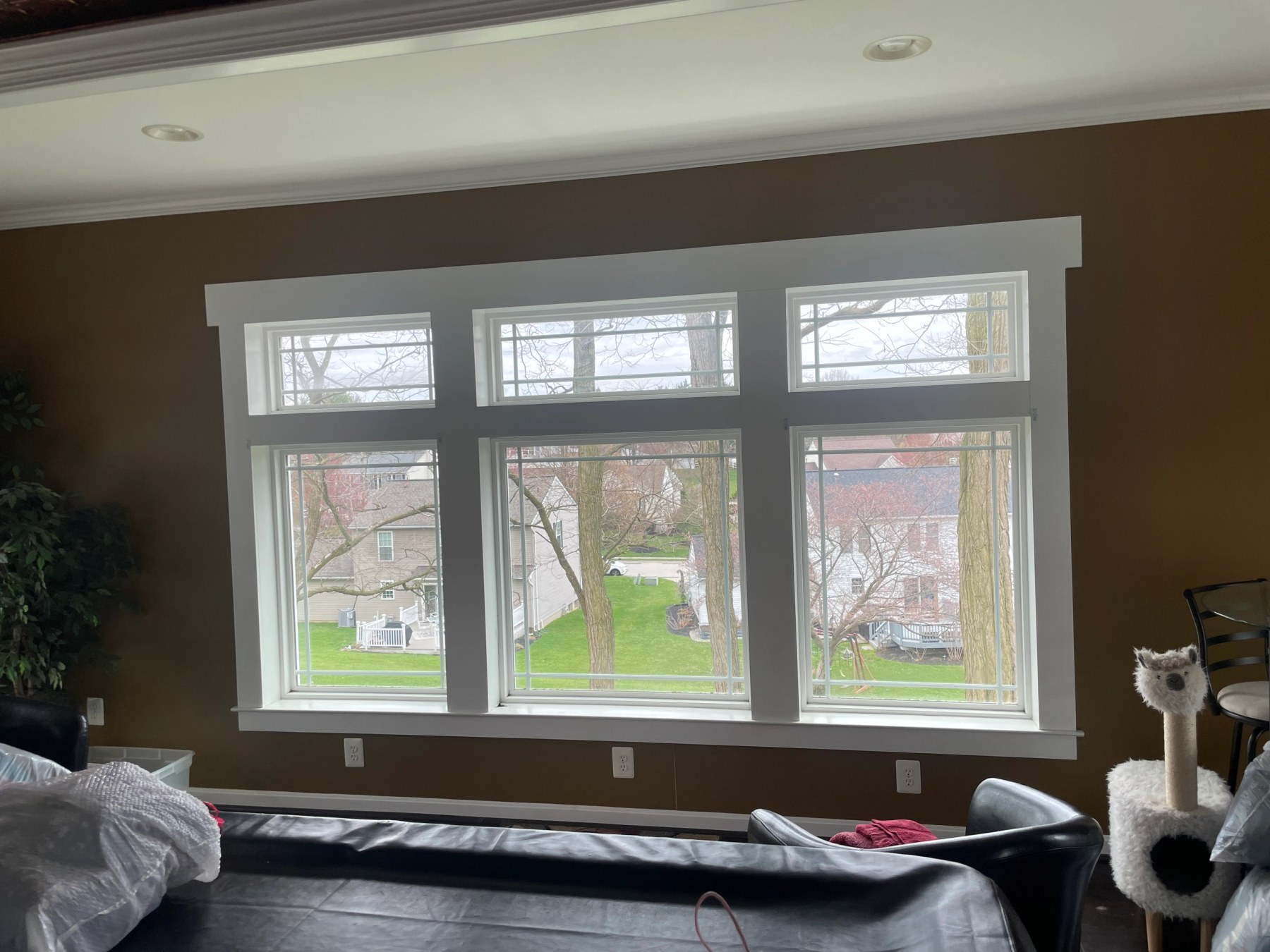 Interior view of a new triple window unit with fresh white casing and a moulded head trim