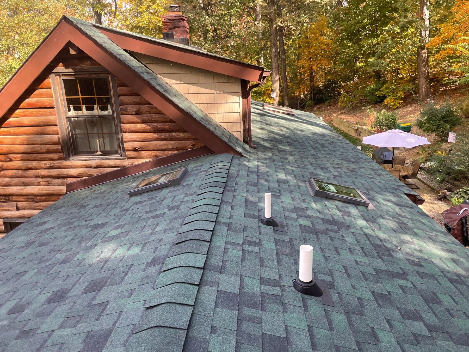 Newly shingled roof with skylights, fresh flashing and a ridge vent on a Maryland log home
